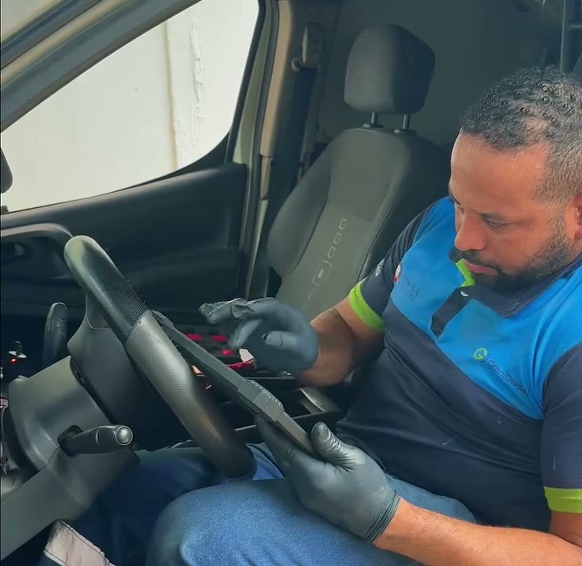 Técnico de OmniDiesel al volante con el equipo de diagnóstico electrónico conectado al vehículo